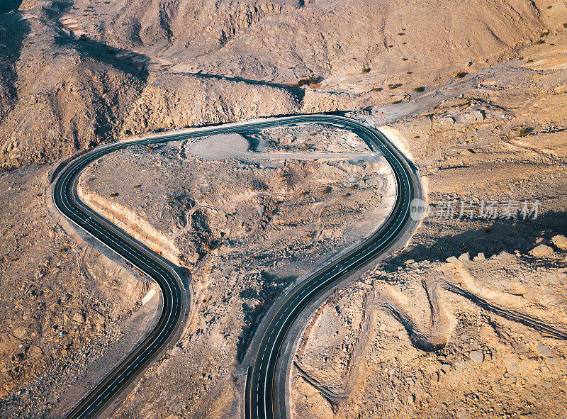 蜿蜒的沙漠道路在杰贝尔贾伊斯砂岩山在Ras Al Khaimah酋长国或阿联酋